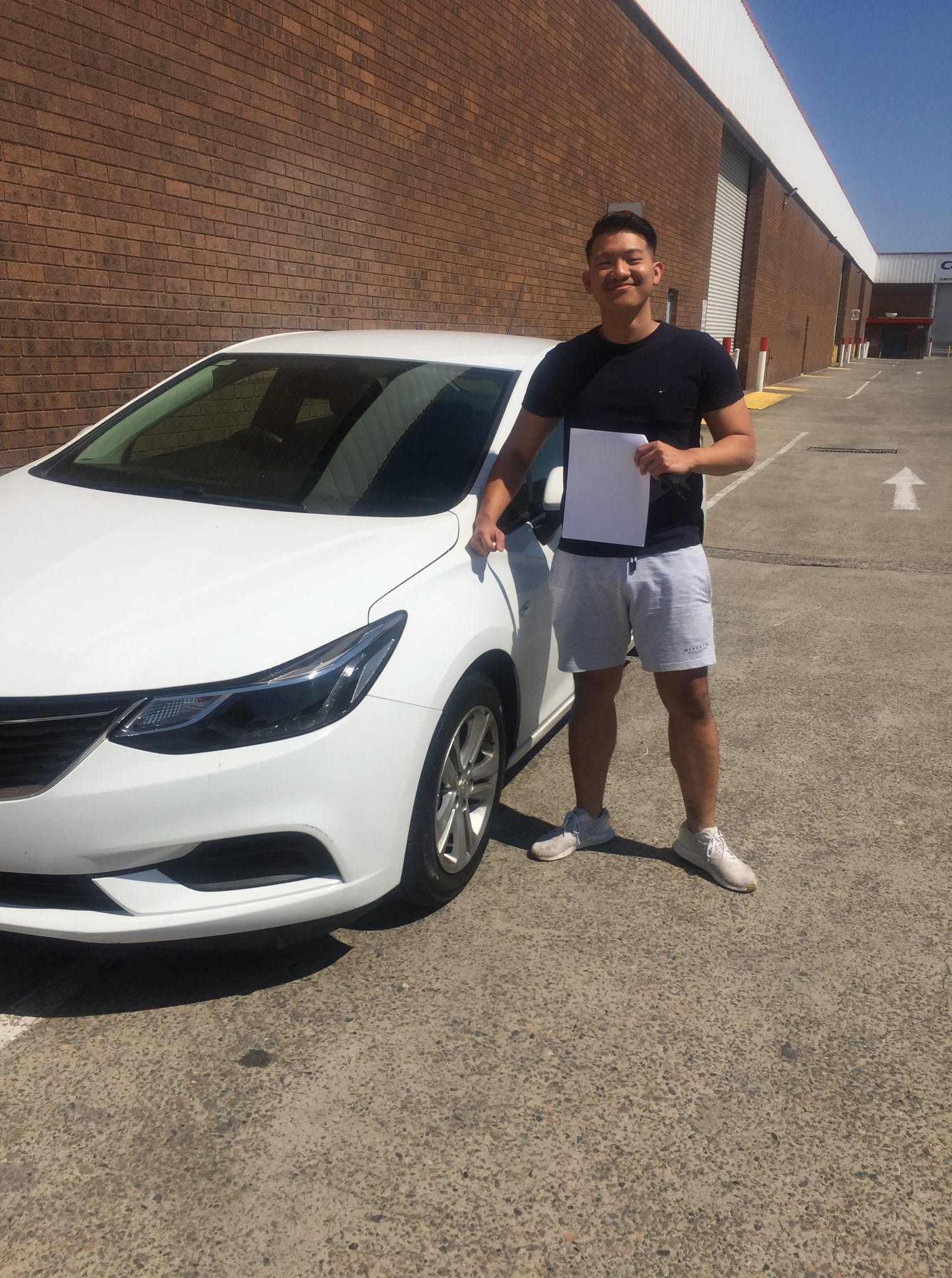 Happy CarNet renter collecting a white sedan